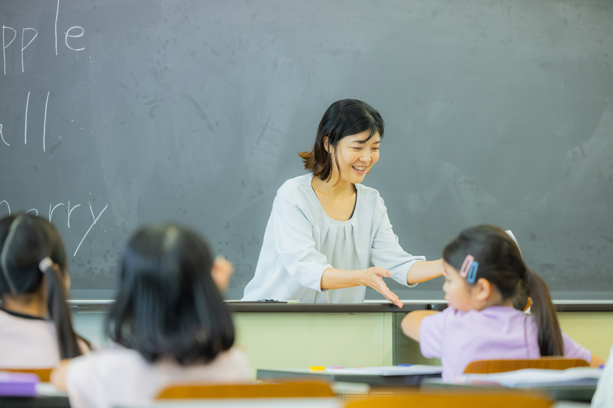 黒板に向かう教師の手元